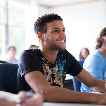 伊玛库拉塔大学的学术指导——一个男生坐在课桌前微笑