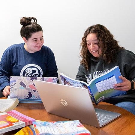Immaculata大学学习支持服务-两名女学生在桌子上用笔记本电脑学习